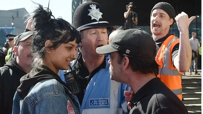 A viral photo of a woman smiling at an English Defence League (EDL) protester in Birmingham was snapped after she stepped in to defend a "fellow Brummie", she has told the BBC.