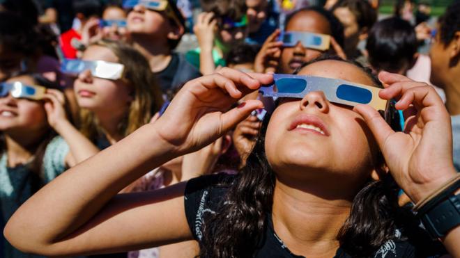 Gente joven viendo un eclipse