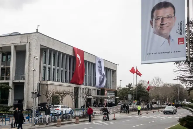 İBB'nin Saraçhane'deki merkez binası önünde yürüyenler ve bir polis