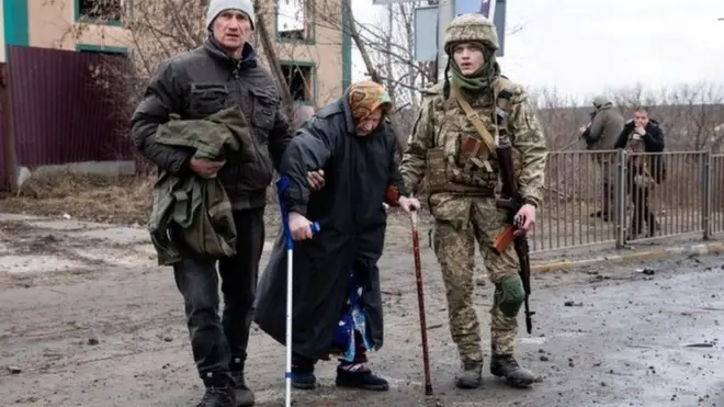Seorang Tentara Ukraina membantu perempuan yang tengah mengungsi di ruas jalan di kota Irpin, Ukraina, 5 Maret 2022.