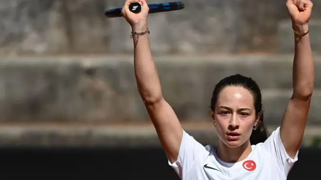 Sönmez, üzerinde Türkiue bayraklı formayla raketini havavaya kaldırmış ve kutluyor