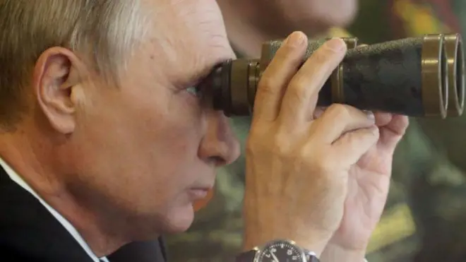 Россия президенти Владимир Путин қўлида дурбин ушлаб турибди. 