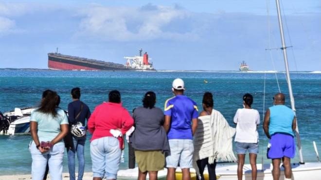 People on shore look out at the MV Wakashio on 6 August 2020.