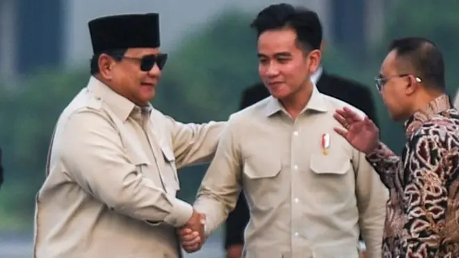 Presiden Prabowo Subianto (kiri) berjabat tangan dengan Wakil Presiden Gibran Rakabuming Raka (tengah) didampingi Wakil Ketua DPR Sufmi Dasco (kanan) saat tiba di Pangkalan Udara TNI AU Halim Perdanakusuma, Jakarta, Rabu (16/07).