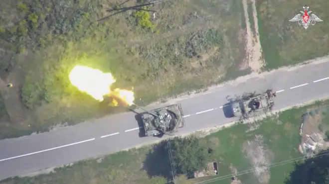 A imagem aérea mostra uma estrada com dois tanquesqual é o melhor aplicativo de aposta de futebolguerra. Um deles está atirandoqual é o melhor aplicativo de aposta de futeboldireção ao lado esquerdo da foto. 