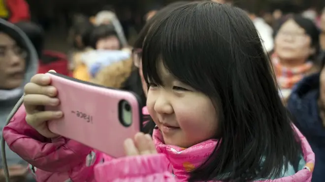 ሞባይል የያዘች ሕጻን 