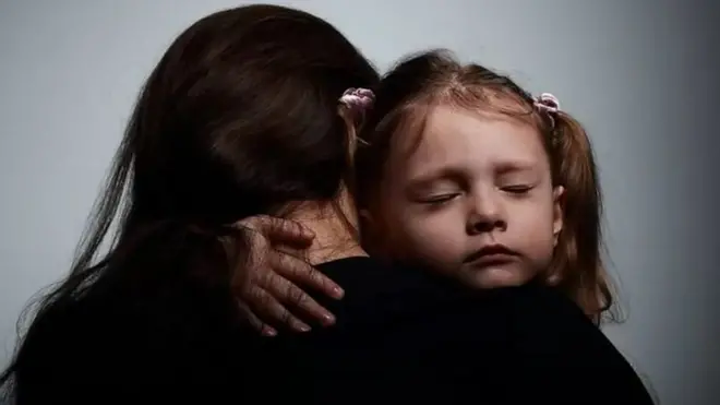 A small child holding her mother