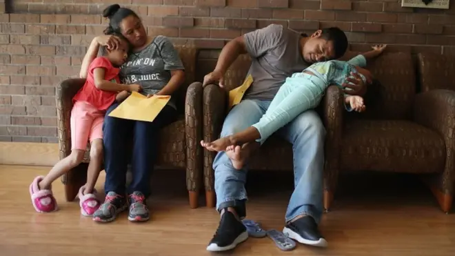 Dua orang tua migran tak berdokumen resmi memeluk anak mereka yang sempat dipisahkan aparat AS.