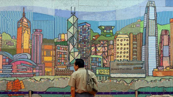 香港郵政總局外一名路人駐足觀賞一面香港海岸線風景壁畫(8/9/2005)