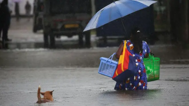 A woman walks through a flooded street in Colombo, on October 15, 2022
