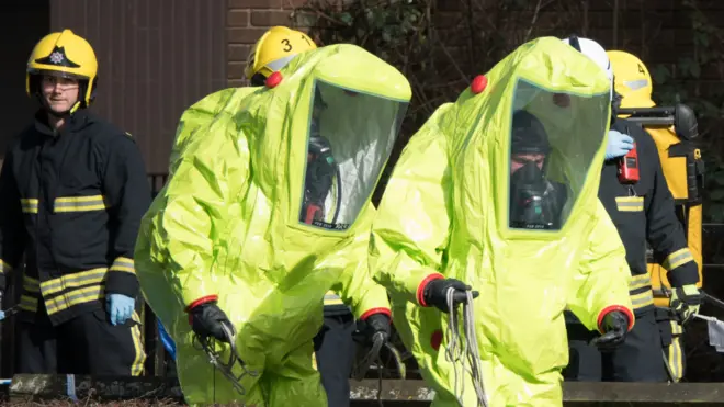 Специалисты в костюмах химзащиты