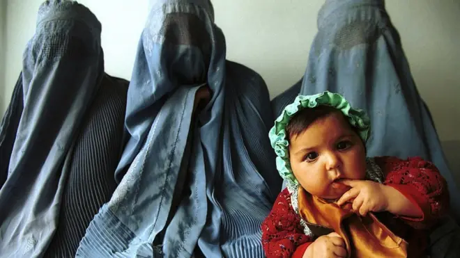 Para perempuan menunggu untuk diperiksa oleh seorang dokter perempuan di sebuah klinik di desa kecil di Herat, Afghanistan, Desember 2000.