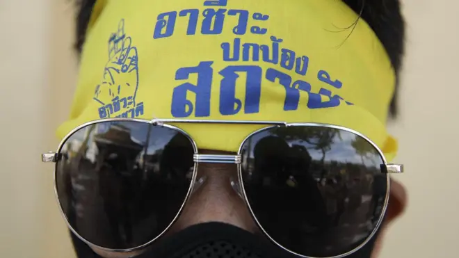 สมาชิกกลุ่มอาชีวะช่วยชาติ คาดผ้าสีเหลืองที่มีข้อความ "อาชีวะปกป้องสถาบัน"