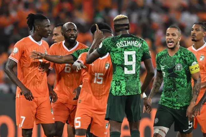 L'attaquant nigérian Victor Osimhen (n° 9) échange des propos avec l'attaquant ivoirien Max-Alain Gradel (n° 15) lors de la finale de la Coupe d'Afrique des Nations (CAN) 2024 opposant la Côte d'Ivoire au Nigeria au stade olympique Alassane Ouattara d'Ebimpe, à Abidjan, le 11 février 2024. 