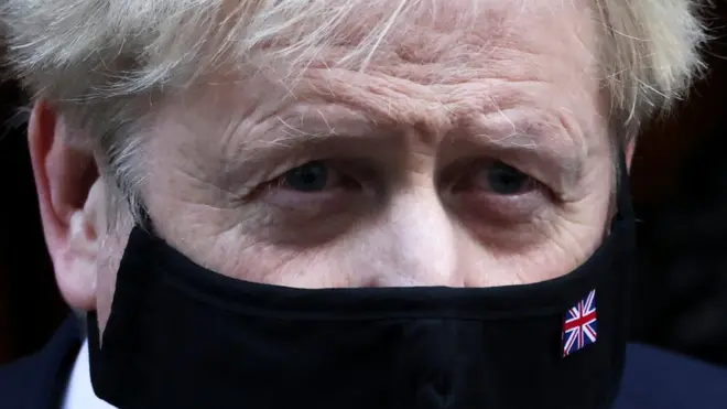 رئيس الوزراء البريطاني بوريس جونسون يسير خارج داونينغ ستريت في لندن، بريطانيا، 12 يناير/كانون الثاني 2022.