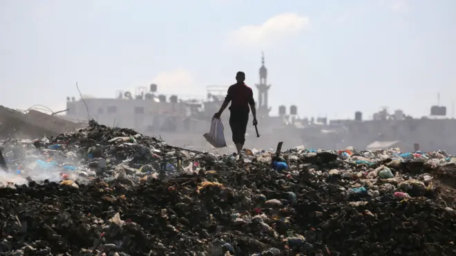 رجل فلسطيني في مكب نفايات القمامة في مخيم البريج وسط قطاع غزة في 7 يوليو/تموز 2025