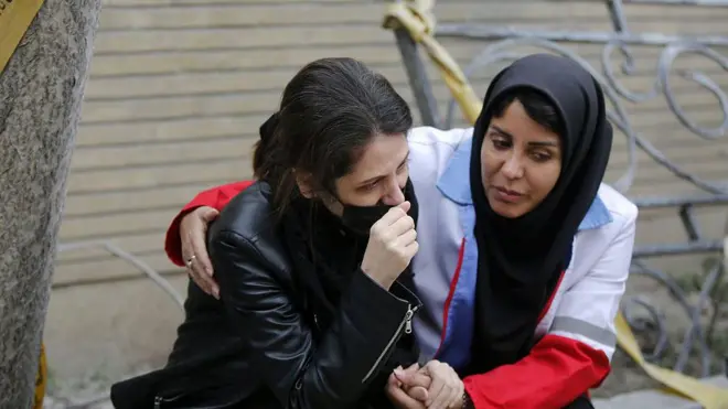 İki İranlı kadın biri diğerinin omzuna elini koymuş, diğeri ağlamaklı. 