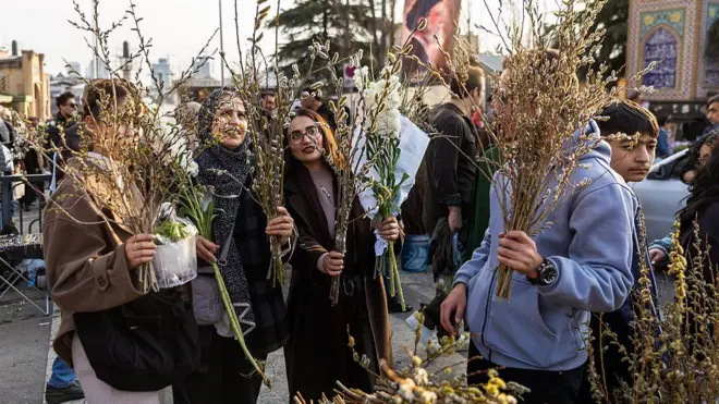 İnsanlar 19 Mart 2026’da İran’ın Tahran kentinde Nevruz kutlamaları öncesinde bir pazarda çiçek satın alıyor.