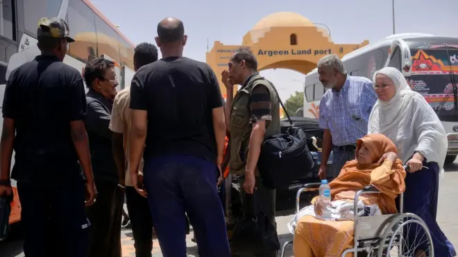 سودانيون يستقلون حافلة بعد العبور إلى مصر عبر ميناء أرقين البري