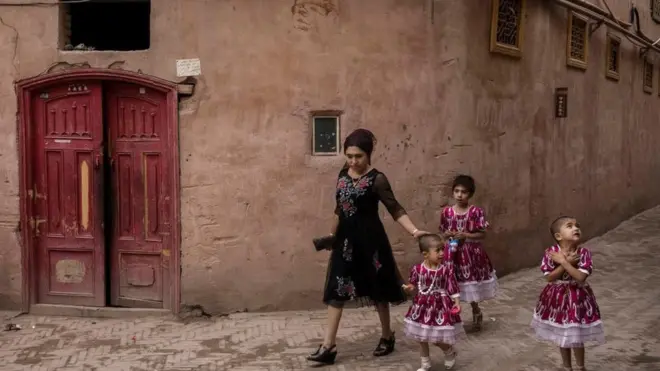 امرأة تسير في مدينة كاشغر القديمة بإقليم شينجيانغ، حيث تواجه السلطات الصينية اتهامات بالعمل على تقليص معدل مواليد الأقليات العرقية