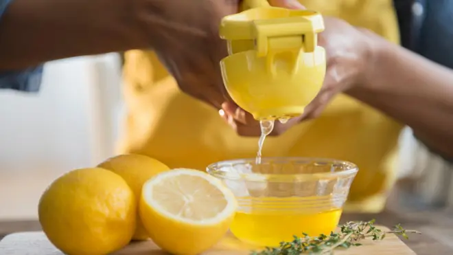 One woman dey squeeze lemons inside bowl