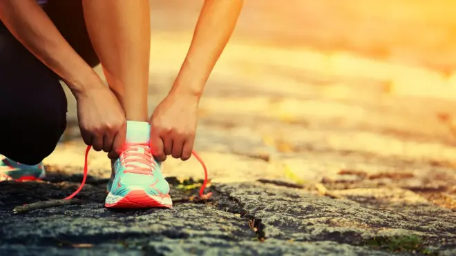 Persona atándose los zapatos