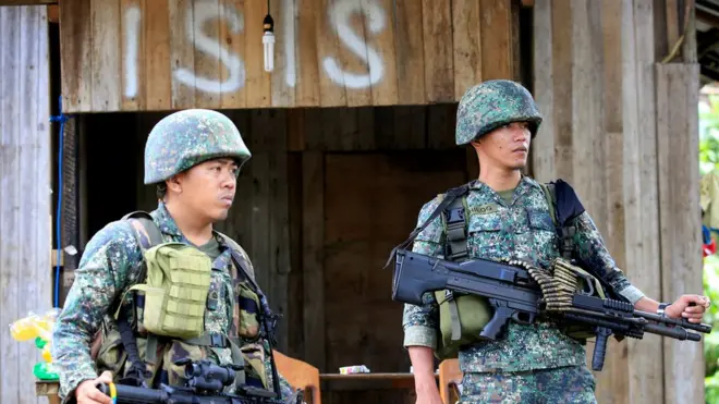 Dua serdadu berjaga di Desa Mapandi selagi militer Filipina melancarkan serangan terhadap kubu penmberontak Maute yang pro-ISIS.