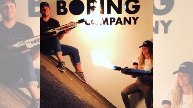 Dos jóvenes aparecen sujetando los lanzallamas y detrás está el aviso de The Boring Company, la empresa de Elon Musk.