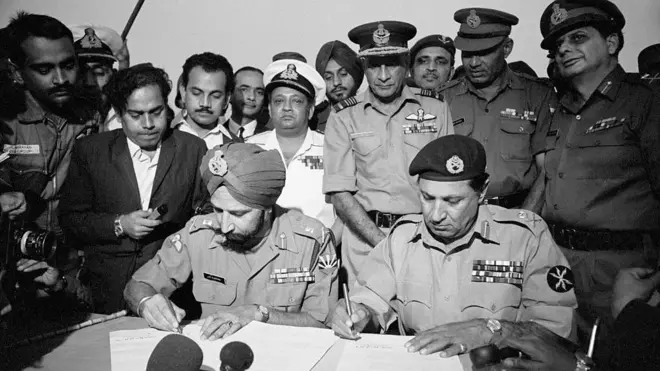 पाकिस्तानी सेना के जनरल अमीर अब्दुल्ला खान नियाजी सरेंडर करने के दस्तावेजों पर हस्ताक्षर किए. साथ में हैं भारतीय सेना के चीफ ऑफ स्टाफ जनरल जगजीत सिंह अरोरा (बाएं).