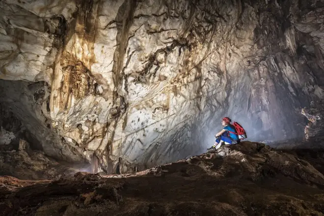 ภาพคนนั่งอยู่ในถ้ำ