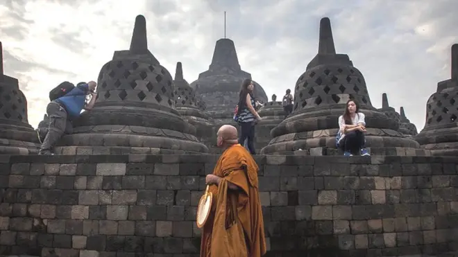 Seorang biksu melakukan ziarah di Candi Borobudur sembari memperhatikan perilaku para wisatawan, pada Mei 2022 lalu.