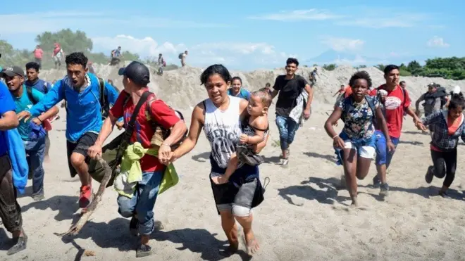 Migrantes corriendo para cruzar el río Suchiate-