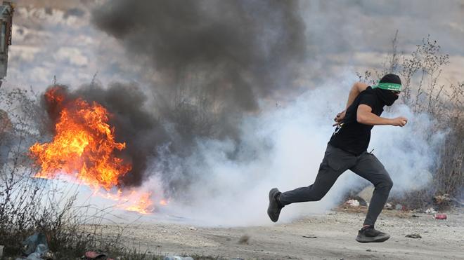 Palestinians burn car tires and block roads as they clash with Israeli forces in Beit El district of Ramallah, West Bank on October 07, 2023