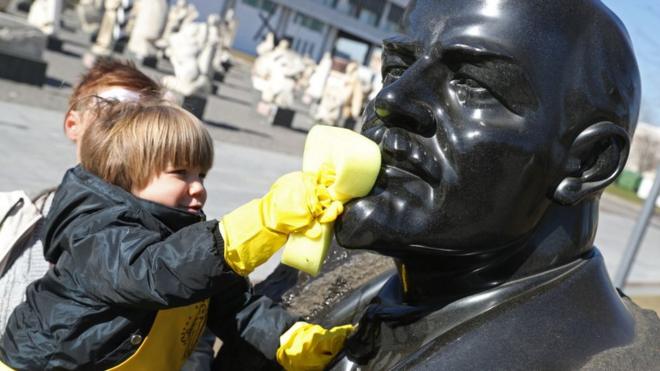 Menino limpa estátua do Lenin na Rússia