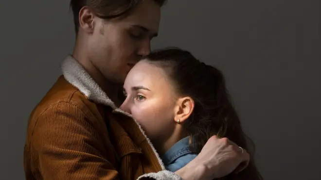 Хлопець обіймає стурбовану дівчину - стокова фотографія