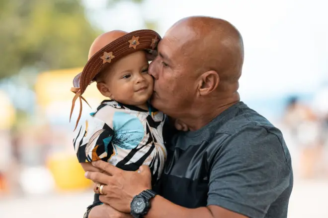 Pai beija o filho com um chapéu de cangaceiro em Olinda, Pernambuco