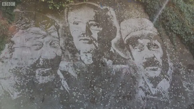 Portreti Pavla Vujisića, Mustafe Nadarevića i Borisa Dvornika na zidu u Brčkom