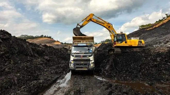 Kendaraan pertambangan memuat material batubara ke dalam truk di tambang batubara terbuka di Kalimantan Selatan, pada 8 Desember 2024.