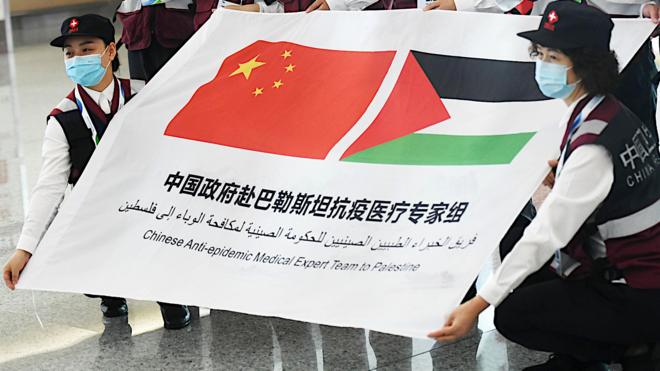 中國赴巴勒斯坦新冠抗疫醫療專家組在重慶江北機場出發前手持中巴旗幟橫幅合影（中新社圖片10/6/2020）