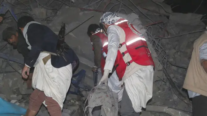 صورة لأشخاص يبحثون بين أنقاض مبنى استهدفته غارة أمريكية في صعدة شمالي اليمن.