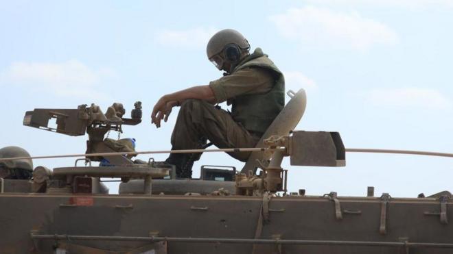 Un soldado israelí sentado sobre un tanque en la frontera con Gaza
