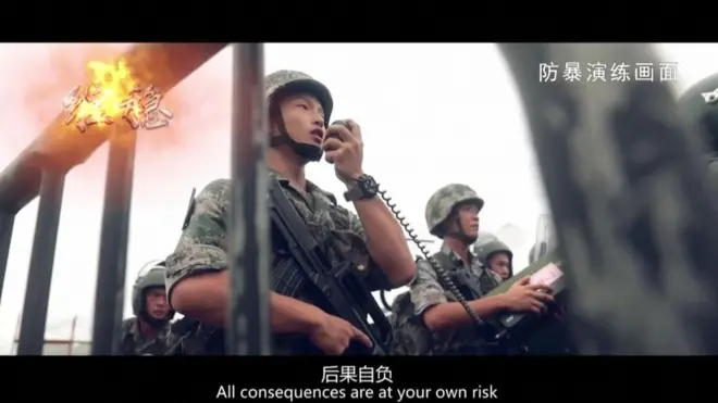 Video yang diunggah militer China memperlihatkan serdadu membawa pelantang suara dengan kalimat: "Anda menanggung risiko atas semua konsekuensi."
