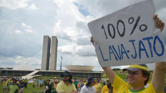 Homem segura cartaz com os dizeres 100% Lava Jato