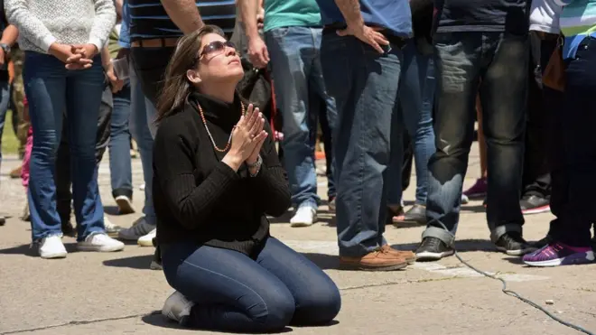 Seorang anggota keluarga awak kapal selam Argentina yang dinyatakan hilang berdoa di antara keluarga lainnya.