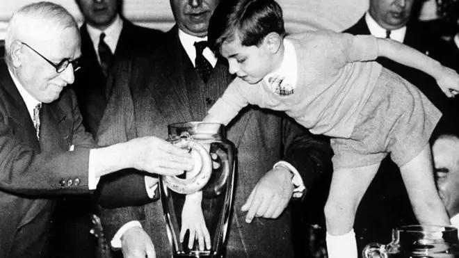 El presidente de la FIFA, Jules Rimet, es asistido por un niño durante el sorteo de la Copa del Mundo de 1938.