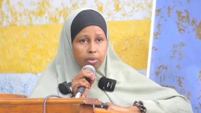 Hodon Mohamud ari imbere y'urukiko arimo kuvugira kuri microphone yambaye umwenda yitandiye kwa kaki ufite n'ibara ry'umukara
