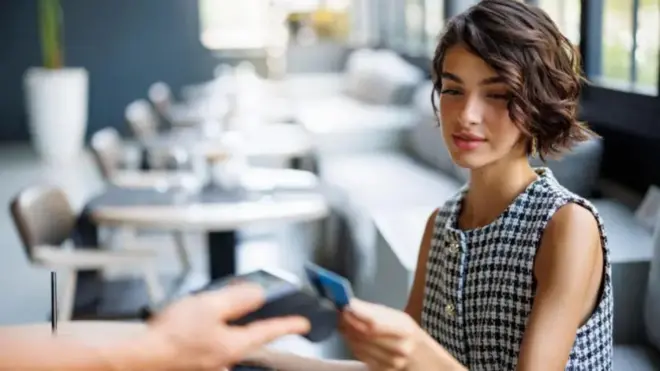 Joven pagando con su tarjeta de crédito