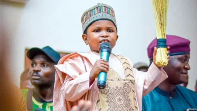 Mahmoud Sadis Buba wọ agbada ati fila, o si tun mu igbalẹ lọwọ