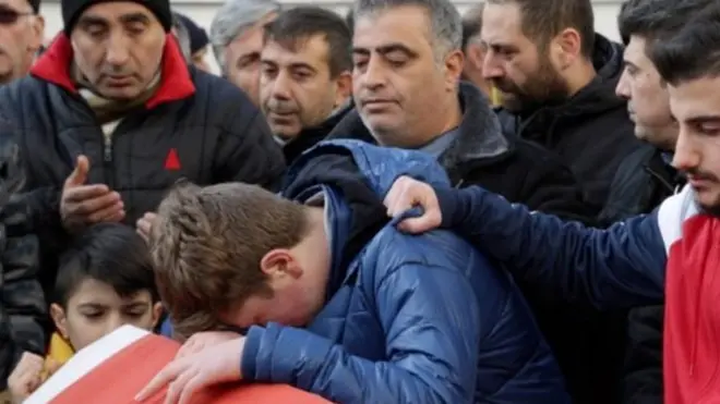 أولاس أريك (في الوسط) يبكي على فقدان والده يوم تشييع الجنازة