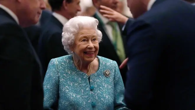 Britain's Queen Elizabeth II (C) and Britain's Prime Minister Boris Johnson (L) greet guests during a reception to mark the Global Investment Summit, at Windsor Castle in Windsor, west of London on October 19, 2021